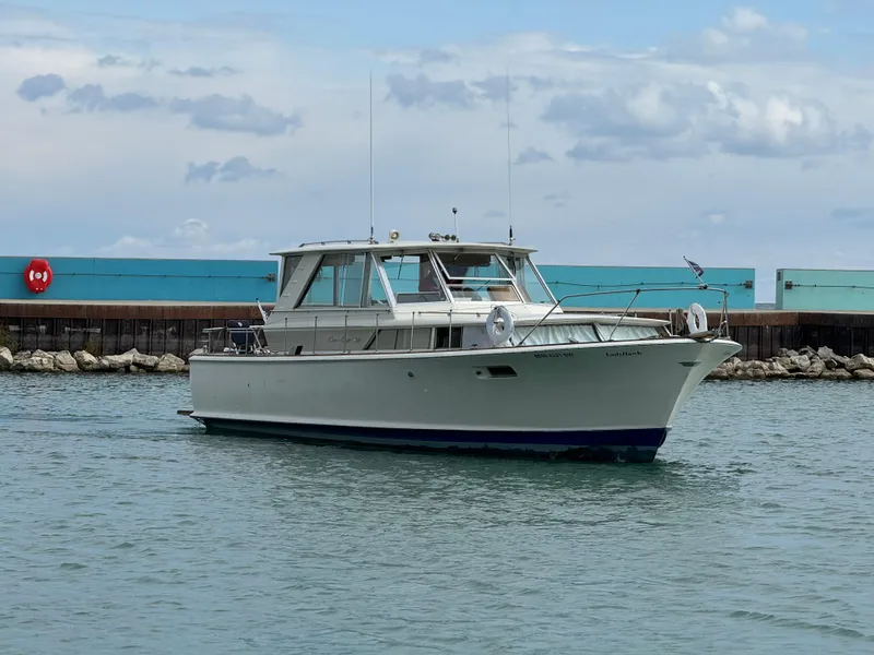Slide: The Image of 1969 Chris-Craft Commander boat on water near a dock under cloudy sky. - 15