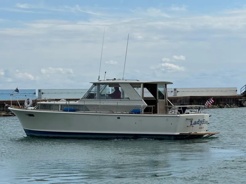 Slide: The Image of 1969 Chris-Craft Commander boat on water, side view, with clear sky background. - 24