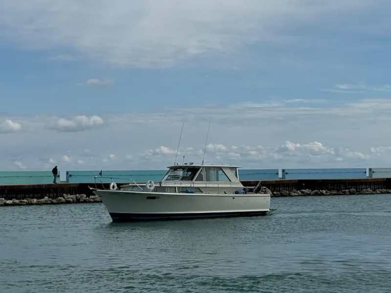 Slide: The Image of 1969 Chris-Craft Commander boat on calm water near a pier under a cloudy sky. - 29