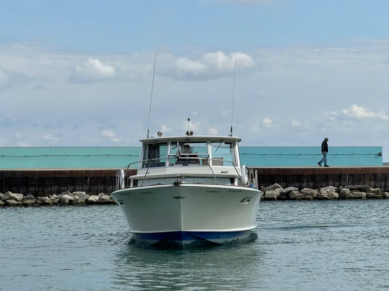 Slide: The Image of 1969 Chris-Craft Commander boat on water near a pier, under a partly cloudy sky. - 32