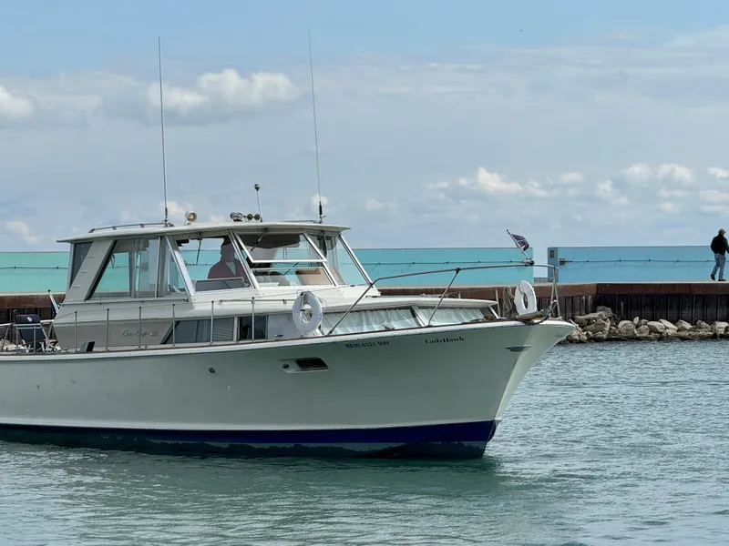 Slide: The Image of 1969 Chris-Craft Commander boat cruising near a pier on a cloudy day. - 36
