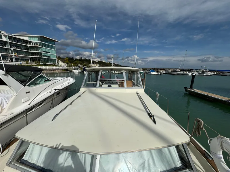 Slide: The Image of 1969 Chris-Craft Commander docked at marina, under a partly cloudy sky. - 39