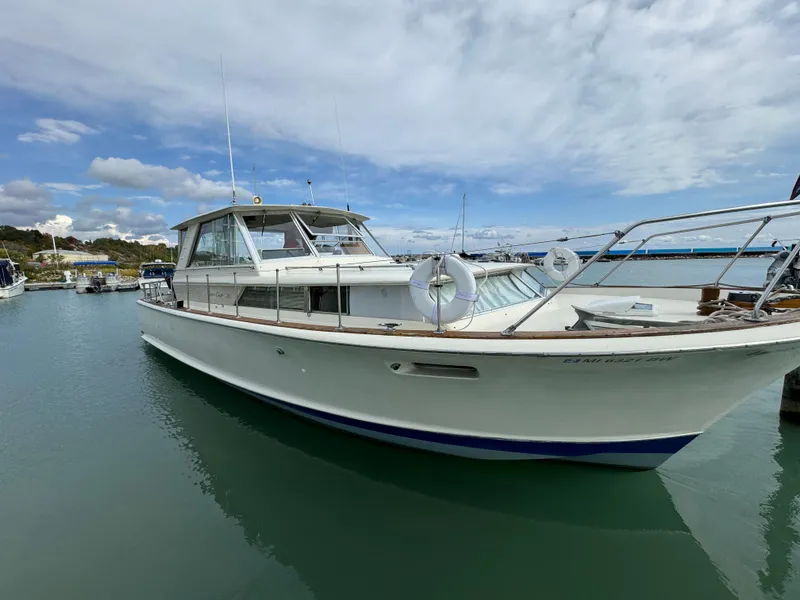 Slide: The Image of 1969 Chris-Craft Commander boat docked in a marina under a partly cloudy sky. - 4