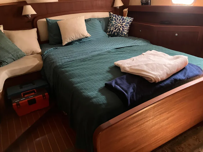 Slide: The Image of Cozy bedroom in 2001 Hunter Passage 450 yacht with teal bedding and decorative pillows. - 14