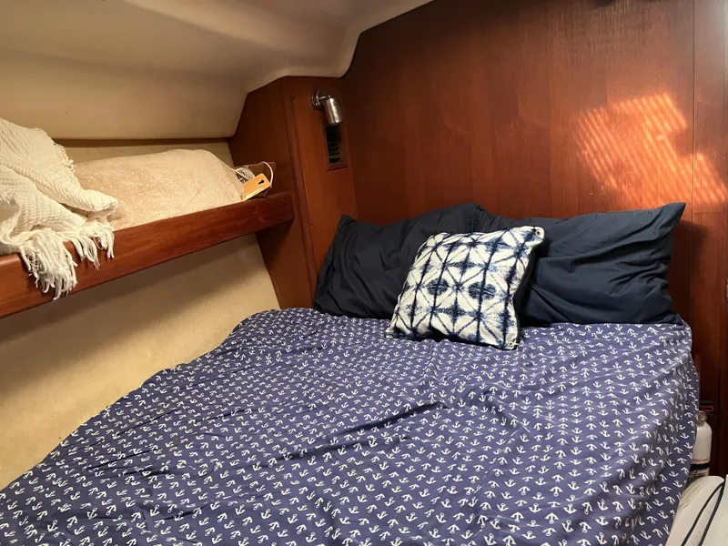 Slide: The Image of Cozy cabin interior of 2001 Hunter Passage 450 sailboat with nautical-themed bedding. - 25