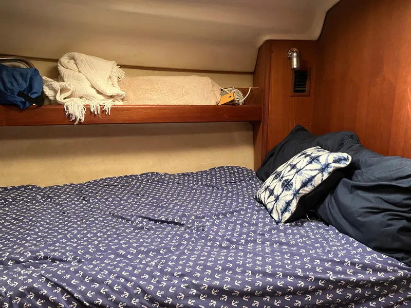 Slide: The Image of Cozy cabin interior of 2001 Hunter Passage 450 sailboat with nautical-themed bedding. - 26
