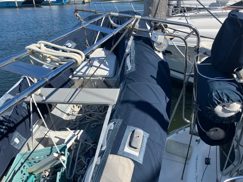 Slide: The Image of 2001 Hunter Passage 450 sailboat docked, featuring blue covers and stainless steel railings. - 34