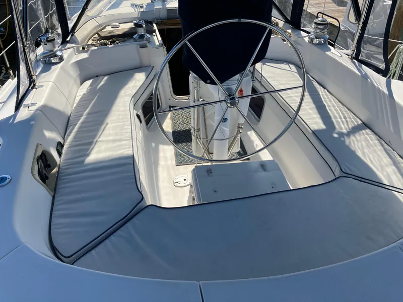 Slide: The Image of 2001 Hunter Passage 450 sailboat cockpit with steering wheel and cushioned seating. - 36