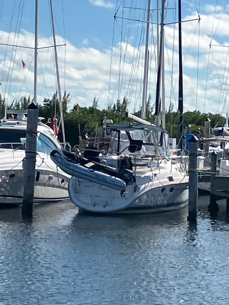 Slide: The Image of 2001 Hunter Passage 450 sailboat docked at a marina, with a dinghy attached. - 39