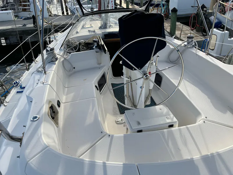 Slide: The Image of 2001 Hunter Passage 450 sailboat cockpit with steering wheel, docked at marina. - 5