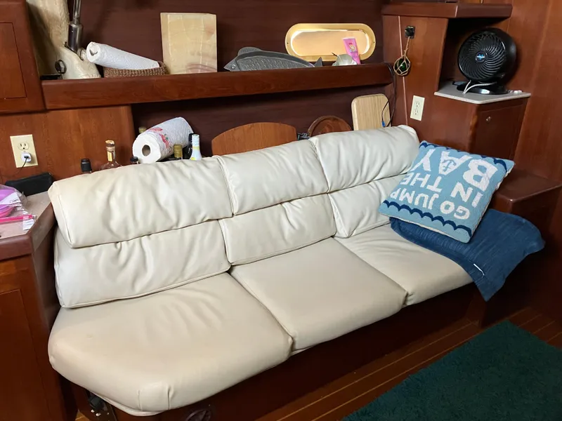 Slide: The Image of Cream leather sofa in a 2001 Hunter Passage 450 yacht interior, with wooden shelves and decor. - 7