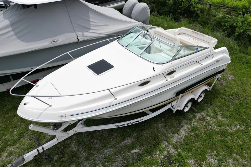 Slide: The Image of 1998 Sea Ray 240 Sundancer boat on trailer, parked on grass. - 1