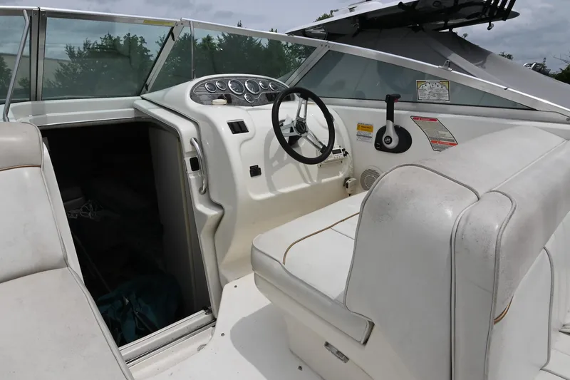 Slide: The Image of 1998 Sea Ray 240 Sundancer boat interior with steering wheel and seating area. - 10