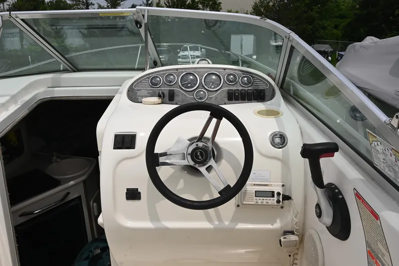 Slide: The Image of 1998 Sea Ray 240 Sundancer boat cockpit with steering wheel and control panel. - 11