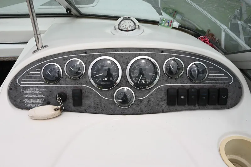 Slide: The Image of Dashboard of a 1998 Sea Ray 240 Sundancer boat with gauges and controls. - 12