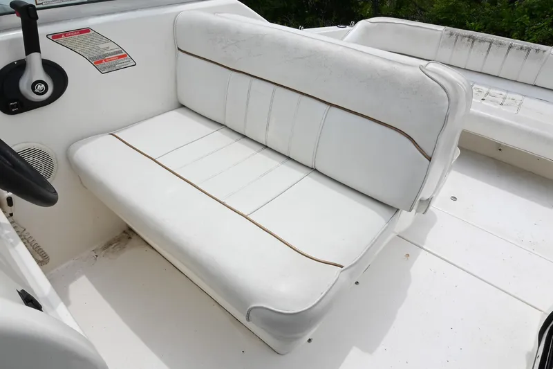 Slide: The Image of White seating on 1998 Sea Ray 240 Sundancer boat, featuring clean upholstery and steering wheel. - 13