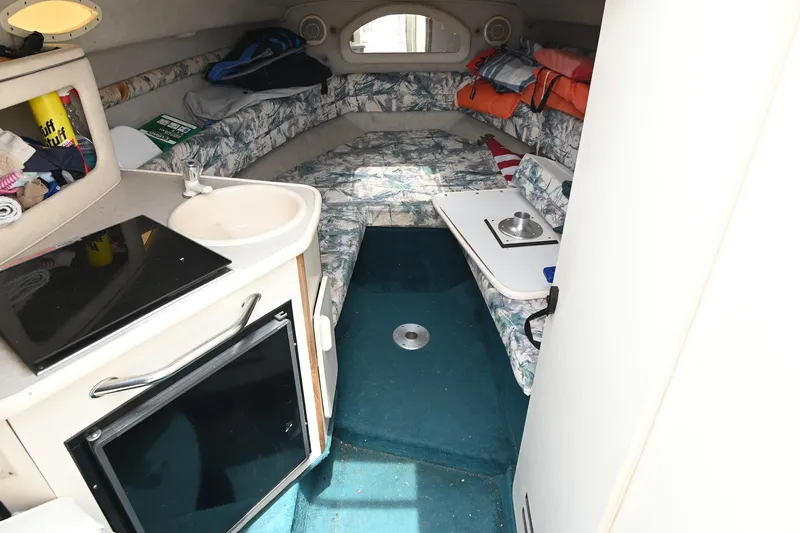 Slide: The Image of Interior of 1998 Sea Ray 240 Sundancer boat with kitchenette and seating area. - 14