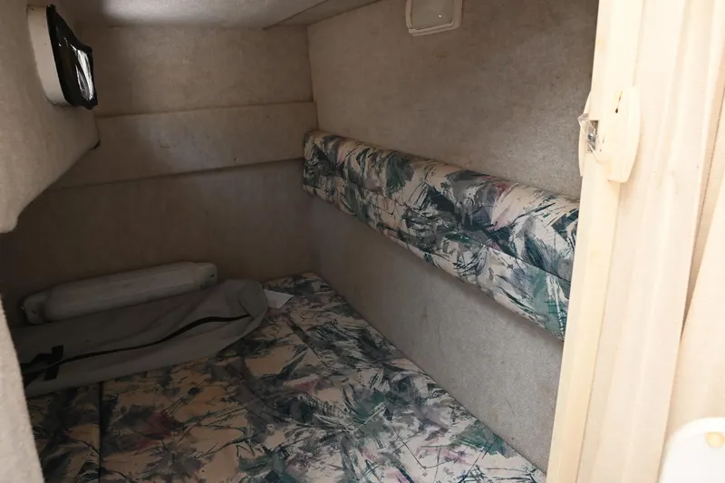 Slide: The Image of 1998 Sea Ray 240 Sundancer cabin interior with floral-patterned bedding and compact design. - 15