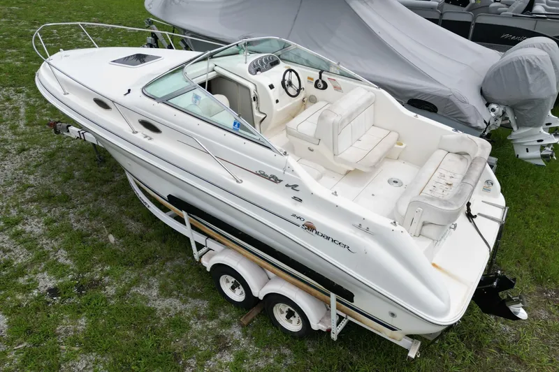 Slide: The Image of 1998 Sea Ray 240 Sundancer boat on trailer, parked on grass. - 2
