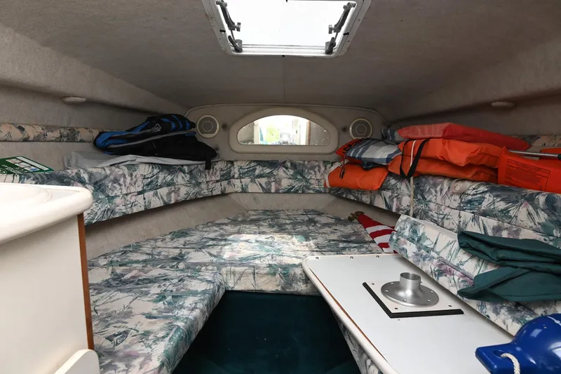 Slide: The Image of 1998 Sea Ray 240 Sundancer cabin interior with seating, life jackets, and storage. - 20