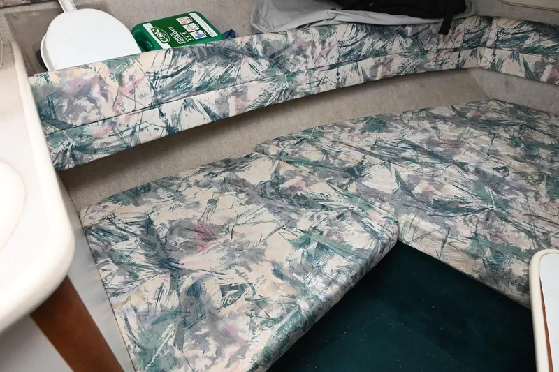 Slide: The Image of 1998 Sea Ray 240 Sundancer cabin interior with patterned seating and storage. - 22