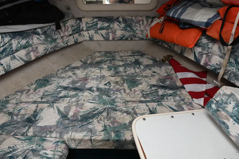 Slide: The Image of 1998 Sea Ray 240 Sundancer cabin interior with patterned upholstery and life jackets. - 23