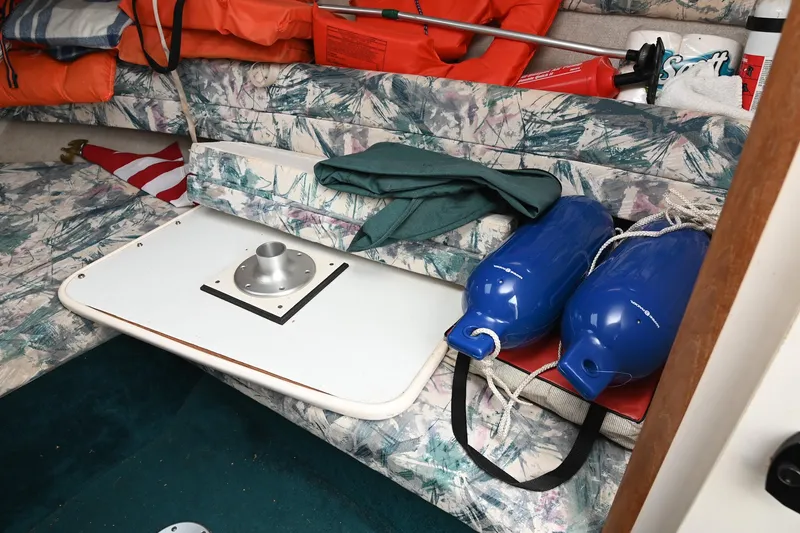 Slide: The Image of Interior of 1998 Sea Ray 240 Sundancer with life jackets, table, and blue fenders. - 24