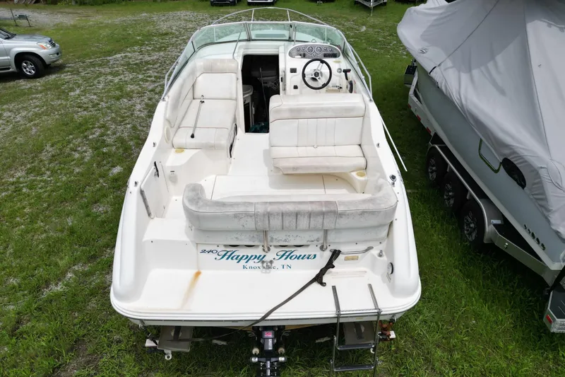 Slide: The Image of 1998 Sea Ray 240 Sundancer boat with white interior, parked on grass. - 3