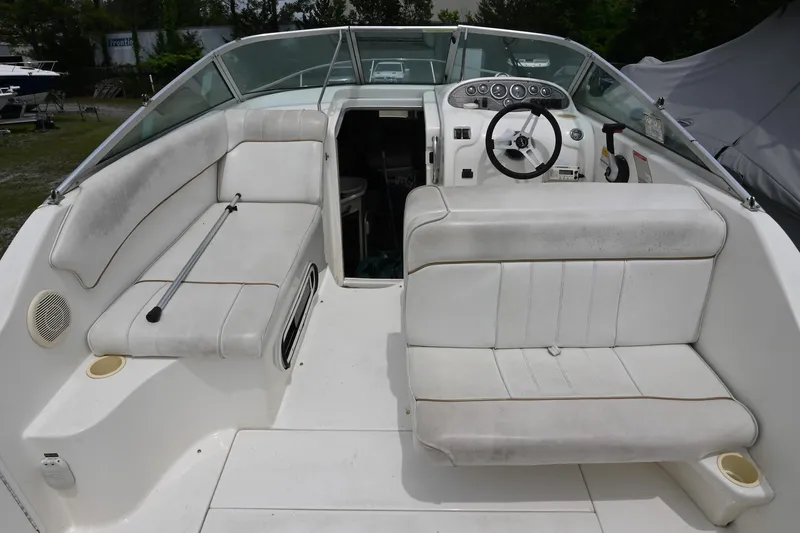 Slide: The Image of 1998 Sea Ray 240 Sundancer boat interior with white seating and steering console. - 5