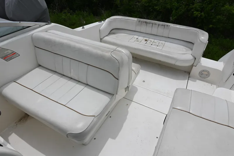 Slide: The Image of 1998 Sea Ray 240 Sundancer boat interior with white seating and spacious layout. - 6