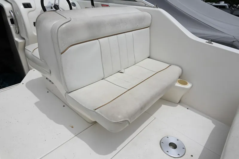 Slide: The Image of 1998 Sea Ray 240 Sundancer boat seat, white upholstery, cup holder, clean deck. - 8