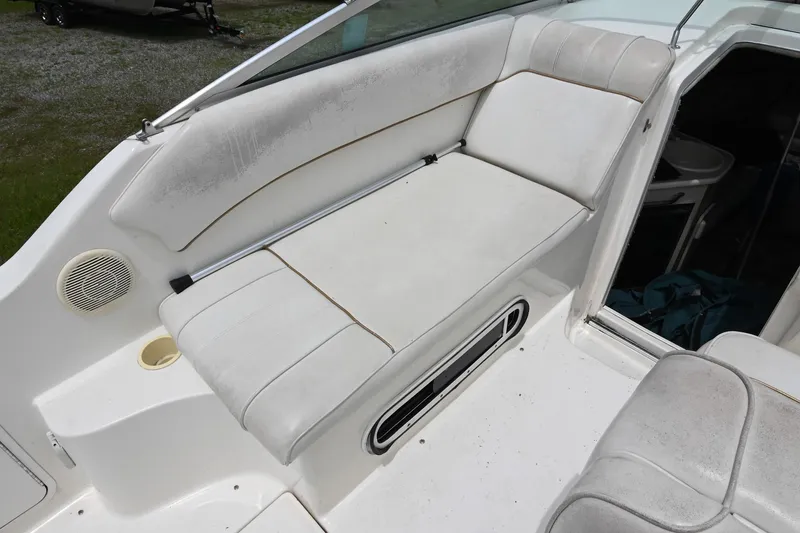 Slide: The Image of 1998 Sea Ray 240 Sundancer boat interior with white seating and speaker. - 9