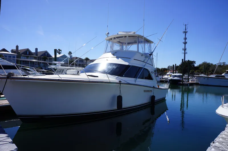 Slide: The Image of 1988 Ocean Yachts Super Sport docked in a marina under clear blue skies. - 1