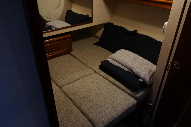 Slide: The Image of 1988 Ocean Yachts Super Sport cabin interior with bed and pillows. - 11