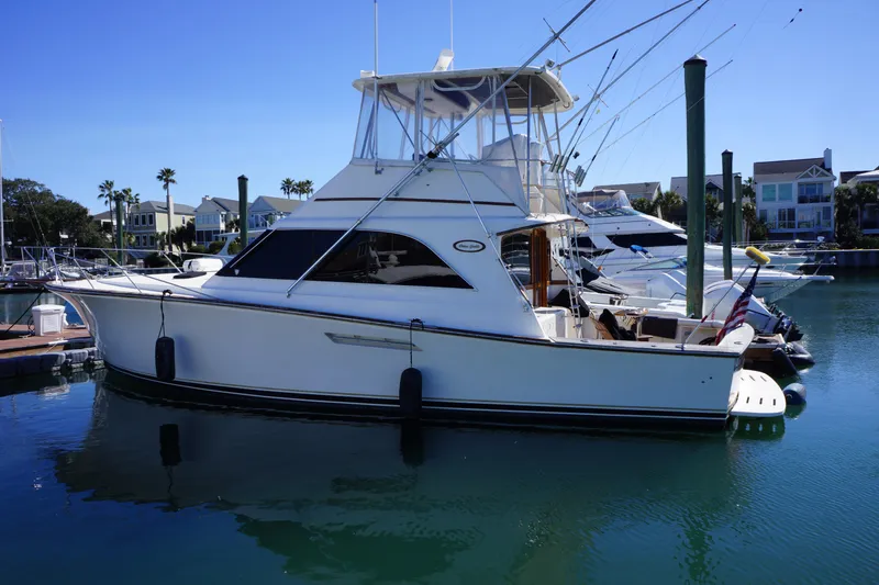 Slide: The Image of 1988 Ocean Yachts Super Sport docked in a marina under clear blue skies. - 2