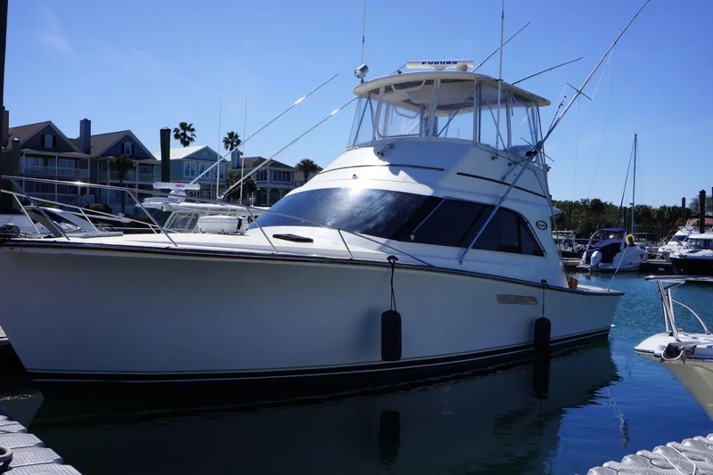 Slide: The Image of 1988 Ocean Yachts Super Sport docked in a marina under clear blue skies. - 3
