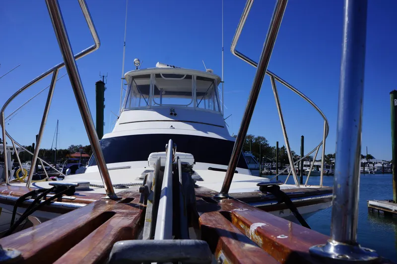 Slide: The Image of 1988 Ocean Yachts Super Sport boat docked, viewed from the bow under a clear blue sky. - 32