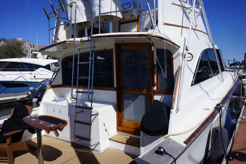 Slide: The Image of 1988 Ocean Yachts Super Sport docked, showcasing rear deck and ladder. - 5