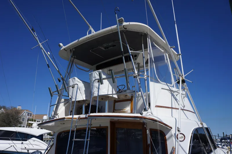 Slide: The Image of 1988 Ocean Yachts Super Sport boat with fishing rods and flybridge, docked at marina. - 6