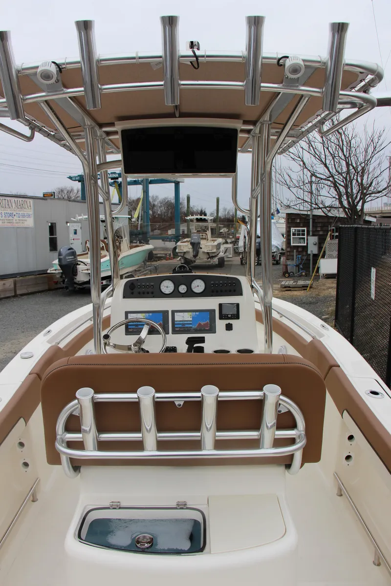Slide: The Image of 2025 Pioneer 202 Sportfish boat interior with rod holders and control panel. - 10
