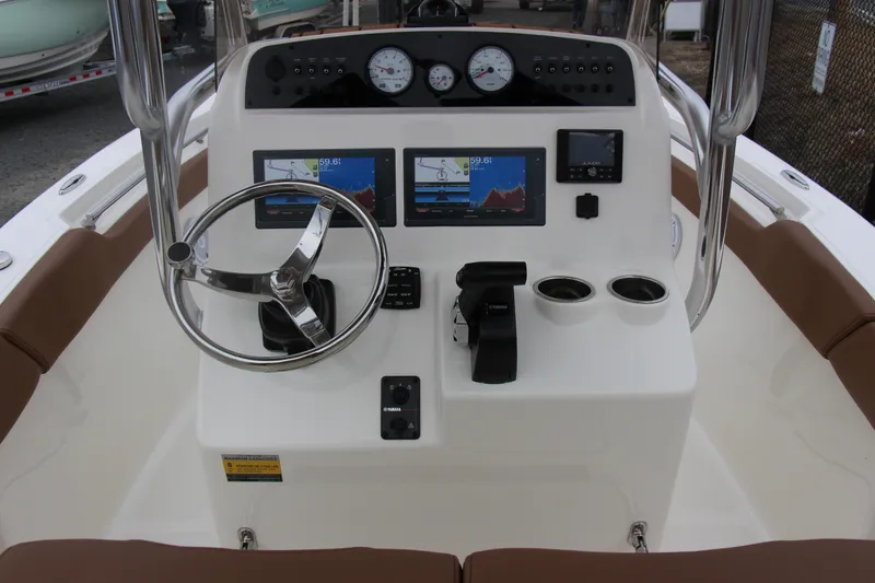 Slide: The Image of 2025 Pioneer 202 Sportfish boat dashboard with steering wheel and navigation screens. - 4