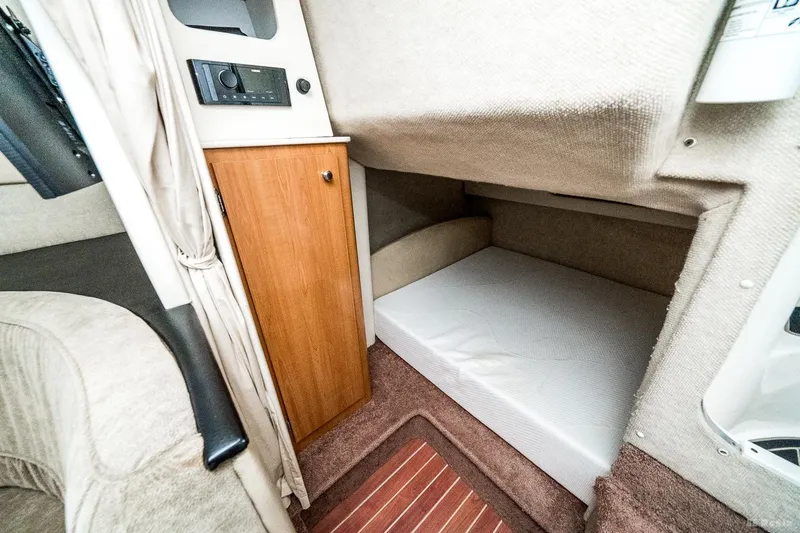 Slide: The Image of 2001 Bayliner 3055 Ciera cabin interior with bed and wooden cabinet. - 13