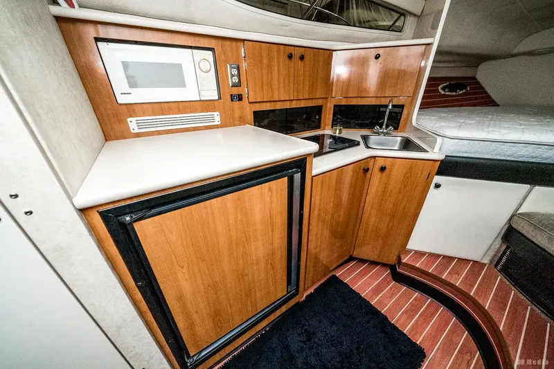 Slide: The Image of 2001 Bayliner 3055 Ciera interior kitchen with wood cabinets, microwave, and sink. - 15