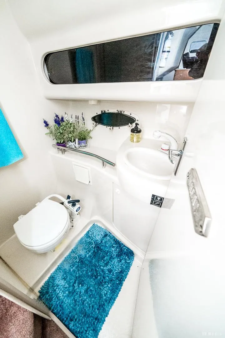 Slide: The Image of 2001 Bayliner 3055 Ciera bathroom with toilet, sink, mirror, and blue rug. - 16