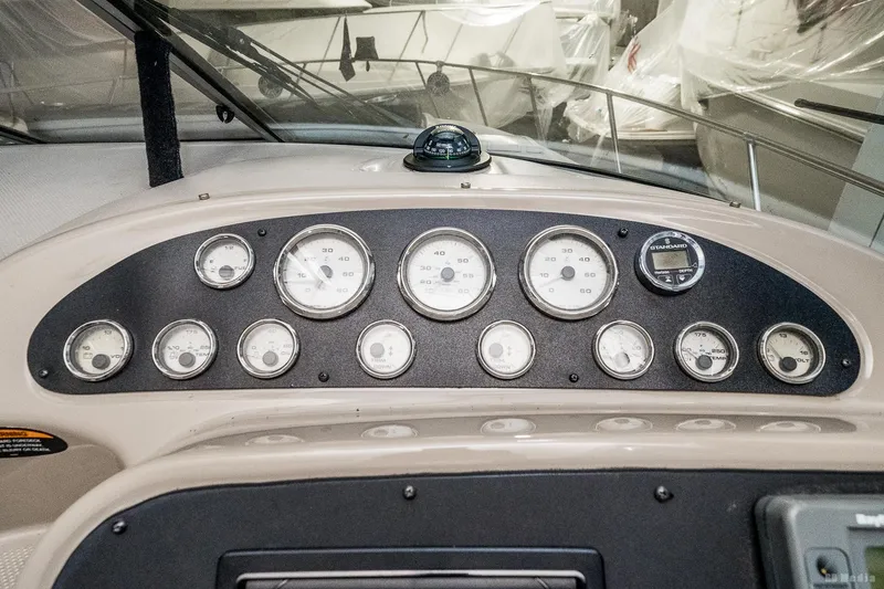 Slide: The Image of Dashboard of a 2001 Bayliner 3055 Ciera boat with multiple gauges and compass. - 25