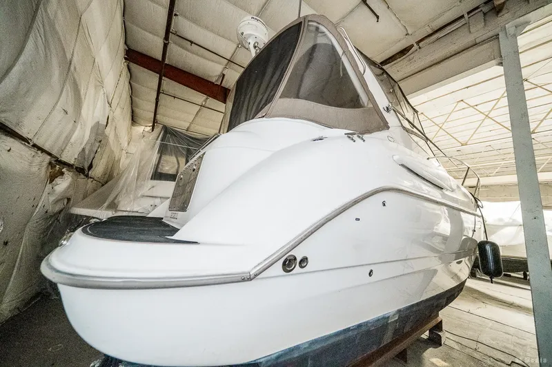 Slide: The Image of 2001 Bayliner 3055 Ciera boat in storage, showcasing sleek design and covered cockpit. - 36
