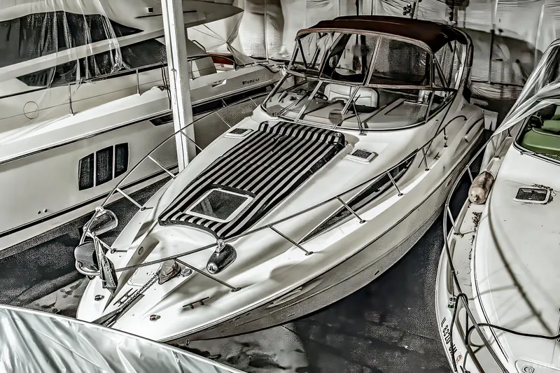 Slide: The Image of 2001 Bayliner 3055 Ciera boat docked indoors, surrounded by other vessels. - 4