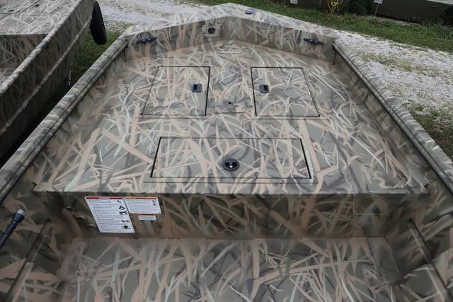 Slide: The Image of 2025 Lowe Roughneck 1760 Tiller boat with camouflage design and storage compartments. - 9