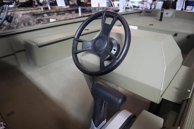 Slide: The Image of 2025 Lowe Roughneck 1860 Rambler boat interior with steering wheel and console. - 12
