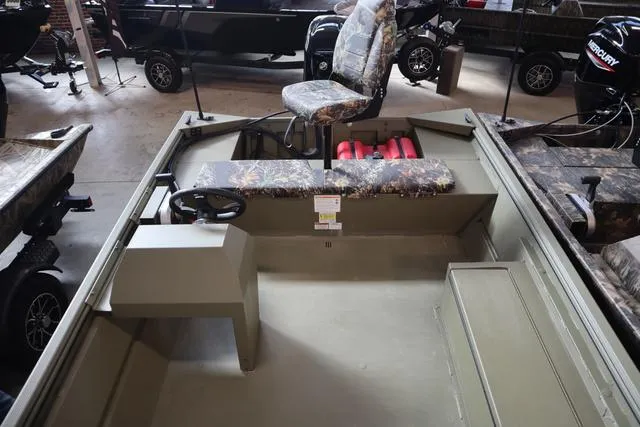 Slide: The Image of 2025 Lowe Roughneck 1860 Rambler boat interior with camo seating and steering console. - 21